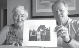  ?? Associated Press ?? ■ Kathy and Steve Dennis pose with a photo they took of some of their grandchild­ren and their phones on Aug. 29 in Bellevue, Wash.