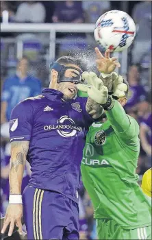  ?? [JOHN RAOUX/THE ASSOCIATED PRESS] ?? Crew SC goalkeeper Zack Steffen, right, deflects the ball away as Orlando City’s Dom Dwyer tries to put a header on goal in the second half of the teams’ 1-1 tie on Saturday.