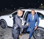  ??  ?? Wayne Hunter (right), branch manager, NCB Montego Bay, exits his escorted Porsche courtesy of ATL Automotive. The driver of the car assists him.