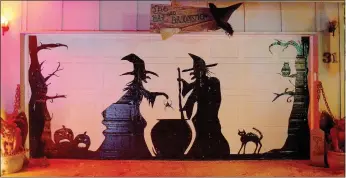  ?? Keith Bryant/The Weekly Vista ?? A pair of witches cook up something spooky on Danelle Knight’s garage door. Knight said she does a different design in duct tape every year on her garage door at 31 Wentworth Drive. Knight said the duct tape is hand-laid, without the aid of tools or a projector, which makes for a lengthy process.