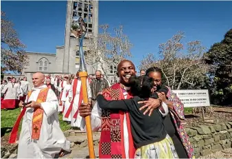  ?? LUZ ZUNIGA/STUFF ?? Bishop Stephen Maina Mwangi and wife Watiri get a hug from their daughter Tanielle as they leave Nelson’s Christ Church Cathedral following his ordination ceremony.