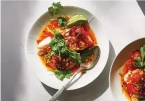  ?? MICHAEL GRAYDON & NIKOLE HERRIOTT/THE NEW YORK TIMES ?? Tomato-poached fish with chile oil and herbs.
