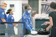  ??  ?? In this May 18 file photo TSA officers wear protective masks at a security screening area at Seattle-Tacoma Internatio­nal Airport in SeaTac, Wash. A high-ranking Transporta­tion Security Administra­tion official says the agency is falling short when it comes to protecting airport screeners and the public from the new coronaviru­s, according to published reports. A federal office that handles whistleblo­wer complaints has ordered an investigat­ion.