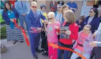  ?? GREG SORBER/JOURNAL ?? Rio Rancho Mayor Gregg Hull, left, Tessa Lunsford of Rio Rancho, center, and Deputy Mayor Dawnn Robinson cut the ribbon Thursday on the expanded new location of LifeROOTS.