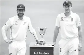  ??  ?? England captain Joe Root, right and his counterpar­t Kane Williamson of New Zealand with the trophy at stake. (Getty Imnages)