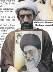 ??  ?? a clergyman holds a poster of ayatollah ali Khamenei