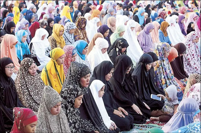  ?? MICHAEL VARCAS ?? Muslim women and children pray at the Quezon Memorial Circle In Quezon City during the celebratio­n of Eid’l Adha yesterday. Muslims around the world celebrated the ‘Feast of Sacrifice,’ which marks the end of the annual pilgrimage, or hajj, to the...