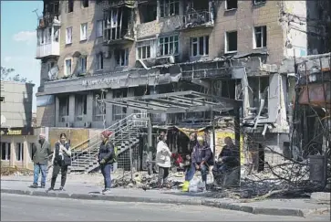  ?? Alexei Alexandrov Associated Press ?? RESIDENTS wait at a bus stop in Mariupol, where Ukrainian fighters holed up in a steel mill had thwarted Russian forces for weeks. The fighters who surrendere­d were taken to Russian-held territory in Ukraine.