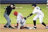  ?? WILFREDO LEE/AP ?? Marlins second baseman Isan Diaz tries to tag out Reds’ Nick Senzel at second as umpire Dan Iassogna calls Senzel safe on Tuesday.