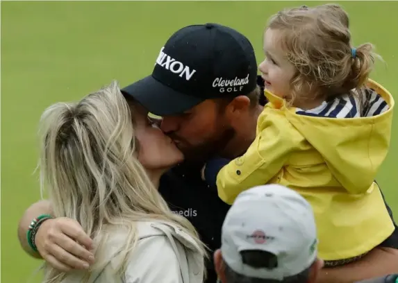  ??  ?? Shane Lowry kisses his wife Wendy Honner and hugs his daughter Iris on the 18th green after winning the Open at Royal Portrush (AP)