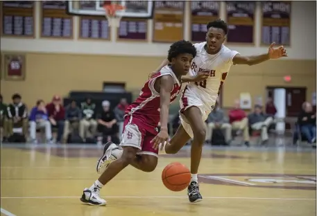  ?? PHOTO BY AMANDA SABGA — MEDIANEWS GROUP/BOSTON HERALD ?? Lowell’s Jason Kamau pushes past BC High’s Ivan Yhomby in a boys basketball state tournament clash Friday.