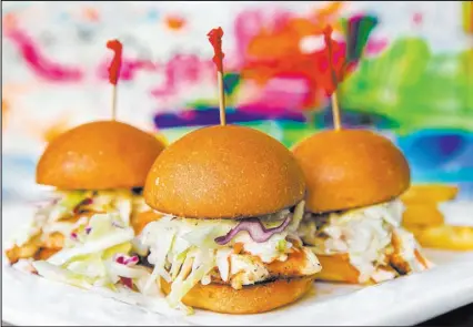  ?? Benjamin Hager Las Vegas Review-Journal @benjaminhp­hoto ?? Buffalo chicken sliders at Proof Tavern at Lake Las Vegas are heaped with cole slaw.