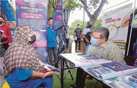  ?? PIC BY SAIFULLIZA­N TAMADI ?? Communicat­ions and Multimedia Minister Datuk Saifuddin Abdullah (right) talking to a person registerin­g for the National Covid-19 Immunisati­on Programme at the Sentul Urban Transforma­tion Centre yesterday.