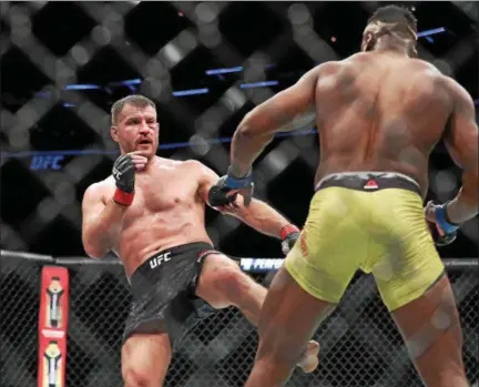  ?? TIM PHILLIS — THE NEWS-HERALD ?? Stipe Miocic kicks Francis Ngannou during their UFC heavyweigh­t championsh­ip bout Jan. 20 in Boston.