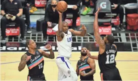  ?? GARY A. VASQUEZ/USA TODAY SPORTS ?? Clippers forward Serge Ibaka (9) passes the ball against the defense of Spurs forward Lamarcus Aldridge (12), guard Demar Derozan (10) and guard Patty Mills (8) during the first half on Tuesday.