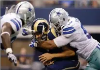  ??  ?? St. Louis Rams’ Sam Bradford is sacked by Dallas Cowboys defensive tackle Jason Hatcher, right, during a game Sunday in Arlington, Texas.