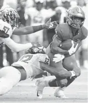  ?? JIM RASSO/AP PHOTOS ?? Florida A&M running back Bishop Bonnett is tackled for a loss by Jackson State defensive back Cam’Ron Silmon (12) and linebacker Nyles Gaddy on Sunday in Miami Gardens.