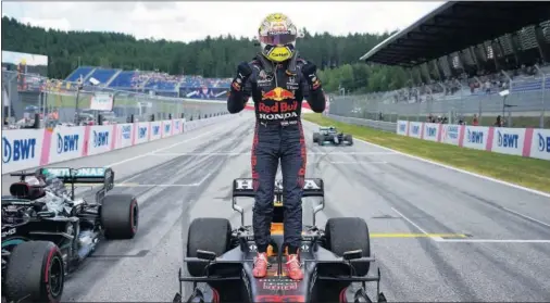  ??  ?? Max Verstappen celebra su triunfo en el GP de Estiria subido encima de su Red Bull, con el Mercedes de Hamilton a su derecha.