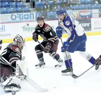  ?? JOHN LAPPA/POSTMEDIA ?? Peterborou­gh Petes goalie Dylan Wells, left, makes a save as teammate Matthew Timms, middle, and Alan Lyszczarcz­yk, of the Sudbury Wolves, look on during OHL action at the Sudbury Community Arena on Friday night. A day after being lifted in a game...