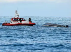  ?? CHRIS SKELTON/STUFF ?? Above: Coastguard members retrieve the capsized boat yesterday. In the main image left, it is being towed to shore.