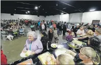  ?? AP PHOTO ?? Evacuees from city’s surroundin­g the Oroville Dam line up for dinner at a shelter Monday.