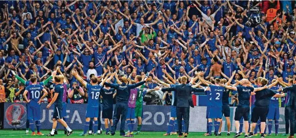  ?? FOTO: DPA ?? Das war der bis jetzt größte Moment in Islands Fußballges­chichte: Spieler und Zuschauer feiern mit dem Hu!-Sprechchor den 2:1-EM-Erfolg über England 2016.
