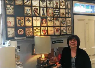  ?? ZACHARY SRNIS — THE MORNING JOURNAL ?? Lori Caffo-Miles stands in front of Sid Dickens art tiles at Details in Avon