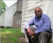  ?? BRUCE SMITH—ASSOCIATED PRESS ?? In this Aug. 14, 2013photo. Joe McGill, who works with the National Trust For Historic Preservati­on, sits outside one of the slave cabins at McLeod Plantation in Charleston, S.C. As part of the Slave Dwelling Project, McGill has slept in old slave dwellings in a dozen states during the past three years to draw attention to the need to preserve the structures and tell their stories.