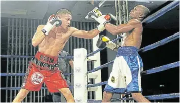  ?? /MICHAEL PINYANA ?? Ludumo Lamati of SA has Luis Mendeles of Colombia against the ropes in their IBF interconti­nental junior-featherwei­ght title fight in East London.