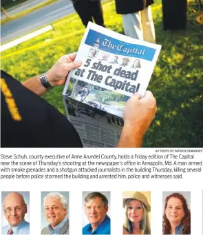  ?? AP PHOTO BY PATRICK SEMANSKY ?? Steve Schuh, county executive of Anne Arundel County, holds a Friday edition of The Capital near the scene of Thursday’s shooting at the newspaper’s office in Annapolis, Md. A man armed with smoke grenades and a shotgun attacked journalist­s in the...