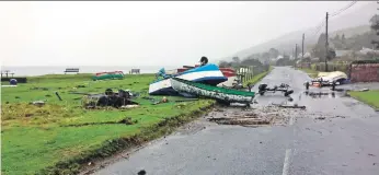  ??  ?? Boats, trailers and parts of a fence were strewn across the main road in Corrie.