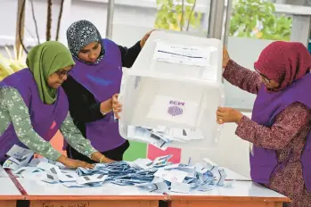  ?? MOHAMED AFRAH/GETTY-AFP ?? Island nation votes: Officials prepare to count votes in the Maldives’ presidenti­al election Saturday at a polling station in Male. Local media reported that opposition candidate Mohamed Muiz, whose party is widely seen as pro-China, won the runoff against incumbent President Ibrahim Mohamed Solih. Official results were expected Sunday.