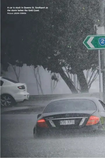  ?? Picture: JASON O'BRIEN ?? A car is stuck in Queens St, Southport as the storm lashes the Gold Coast.