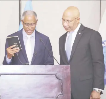  ??  ?? Justice Adrian Saunders (left), newly sworn-in President of the CCJ, takes the oath of office administer­ed by Sir Patrick Allen, Governor-General of Jamaica.