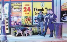  ?? ANDREW COLLINS SPECIAL TO THE HAMILTON SPECTATOR ?? Police search the area after a man reportedly waved a loaded handgun in Hess Village. A suspect was arrested nearby.