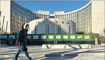  ?? JIANG QIMING / CHINA NEWS SERVICE ?? A pedestrian walks past the headquarte­rs of the PBOC in Beijing.