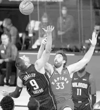  ?? STEPHEN M. DOWELL/ORLANDO SENTINEL ?? Orlando center Nikola Vucevic (9) and Toronto center Marc Gasol (33) vie for the ball Wednesday night.