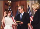  ?? Hans Pennink / Associated Press ?? New York Chief Judge Janet DiFiore swears in Kathy Hochul as the first woman to be New York's governor while her husband Bill Hochul holds a bible during a ceremonial swearing-in ceremony at the state Capitol on Tuesday, in Albany, N.Y.