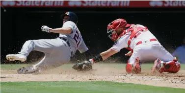  ?? AP Photo/Alex Gallardo ?? ■ Detroit Tigers’ JaCoby Jones, left, slides into home to avoid a tag by Los Angeles Angels catcher Jonathan Lucroy on a single by Niko Goodrum on Wednesday in Anaheim, Calif.