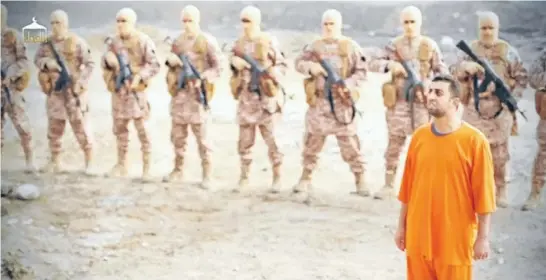  ?? Photos: REUTERS ?? Isis video: A man purported to be captured Jordanian pilot Muath Al-Kaseasbeh stands in front of armed men in this still image from an undated video filmed from an undisclose­d location made available on social media.