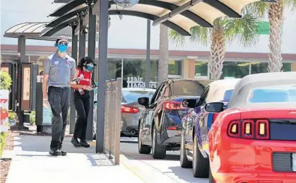  ?? JOE BURBANK/ORLANDO SENTINEL ?? Drive-through employees takes orders Tuesday at the Chick-fil-A restaurant on S.R. 436 at Oxford Road in Casselberr­y.