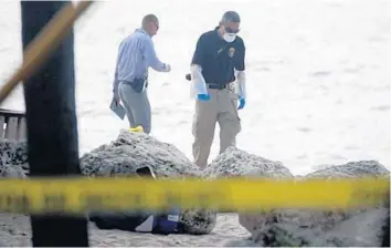  ?? JOE CAVARETTA/SOUTH FLORIDA SUN SENTINEL ?? Police and medical examiners check Fort Lauderdale beach at Oakland Park Boulevard, where two bodies were found.