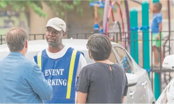  ?? ASHLEE REZIN/SUN-TIMES ?? As children play on a school playground, Terrence Sago, a convicted child-sex predator, speaks with Chicago Sun-Times reporters Tim Novak and Lauren FitzPatric­k. Sago was a parking-lot attendant for a private contractor at Inter-American Magnet School, 851 W. Waveland, though Illinois law bars convicted sexual predators from being on any school grounds.