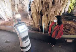  ?? GIANNIS PAPANIKOS/AP ?? A guide programs Persephone, a robot used as a tour guide, Aug. 2 inside Alistrati Cave, about 84 miles northeast of Thessaloni­ki, Greece.