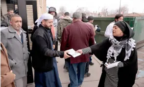  ?? ?? Samra’a Luqman (right) hands out fliers outside of the American Moslem Society Mosque to ask voters not to vote for President Joe Biden after Friday prayers in Dearborn Heights, Michigan.