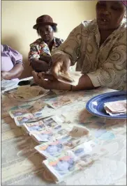  ?? PHOTO: AP ?? Monies are counted at a Stokvel meeting in Nhlazuka, KZN. The savings and loan clubs have been advised to be on alert.