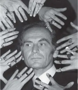  ?? AP, file 1969 ?? French fashion designer Pierre Cardin’s face is framed by hands of models ornamented with rings designed by Cardin. ‘Fashion is not enough. I don’t want to be just a designer,’ he said.