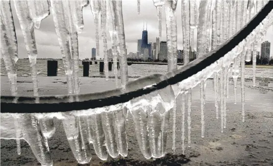  ?? AL PODGORSKI/SUN-TIMES FILE PHOTO ?? Cold temperatur­es, strong winds and heavy lake wave action covered piers in a layer of ice off the lakefront near North Avenue on Jan. 2, 2003.