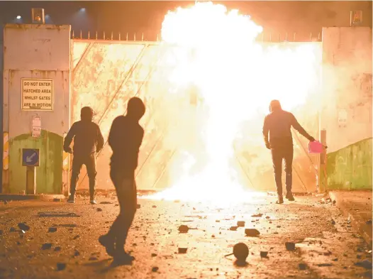  ?? Charles Mcquillan / Getty Images ?? Youths set fire to the gates of the peace wall at the Springfiel­d Road/lanark Way interface in Belfast last week.