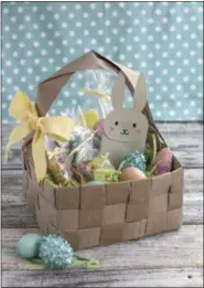  ?? LILA GRIFFITH VIA AP ?? This undated photo shows an upcycled DIY Easter basket made from four brown paper grocery bags, cut into strips and woven together. Fresh takes on Easter baskets for kids include a heavy dose of do-it-yourself ingenuity.